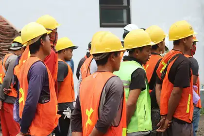 Cuadrilla de trabajadores con casco y chaleco reflejante