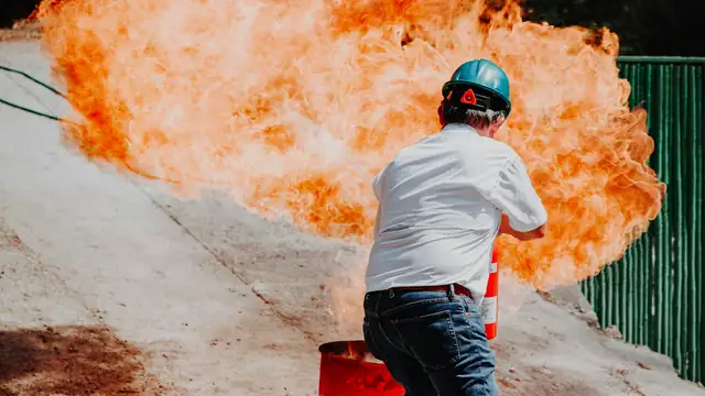 Participante practica con un extintor frente a una llamarada durante una capacitación
